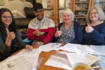 Group of 4 people sitting round a table with thumbs up