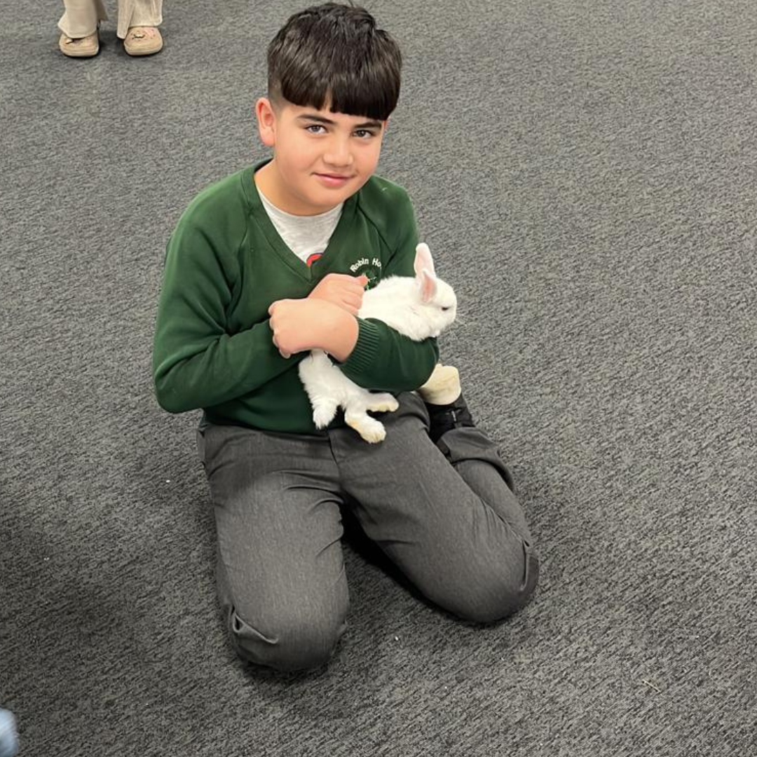 Afghan boy holding a white Rabbit
