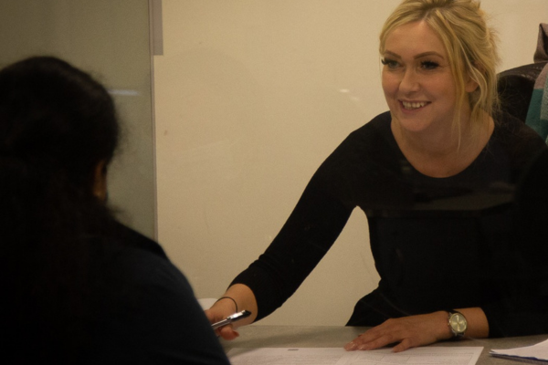 Female volunteer helping a client fill out their benefit form
