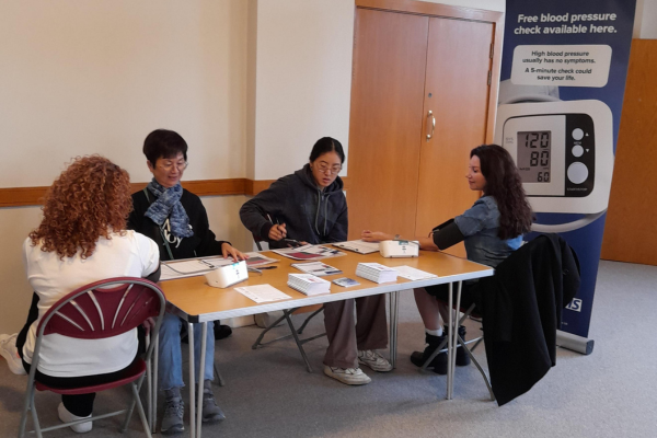 Two Health Navigator volunteers providing free blood pressure checks to local residents