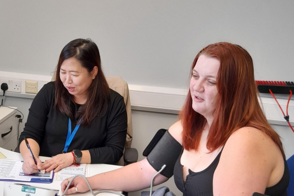 Health Navigator Volunteer giving a blood pressure check to a local resident